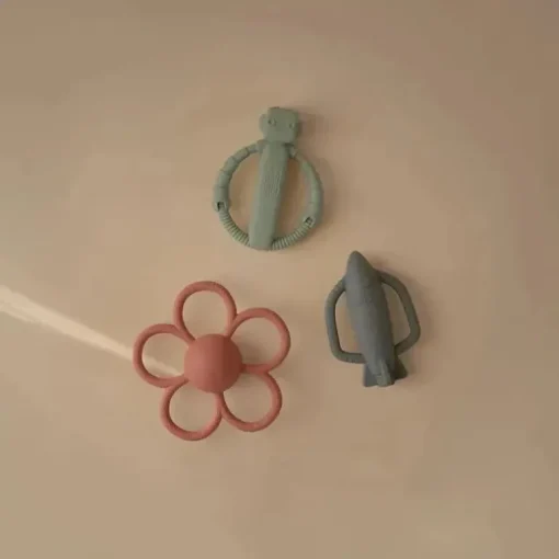 Mushie - Brinquedo mordedor de silicone para bebê com chocalho de foguete